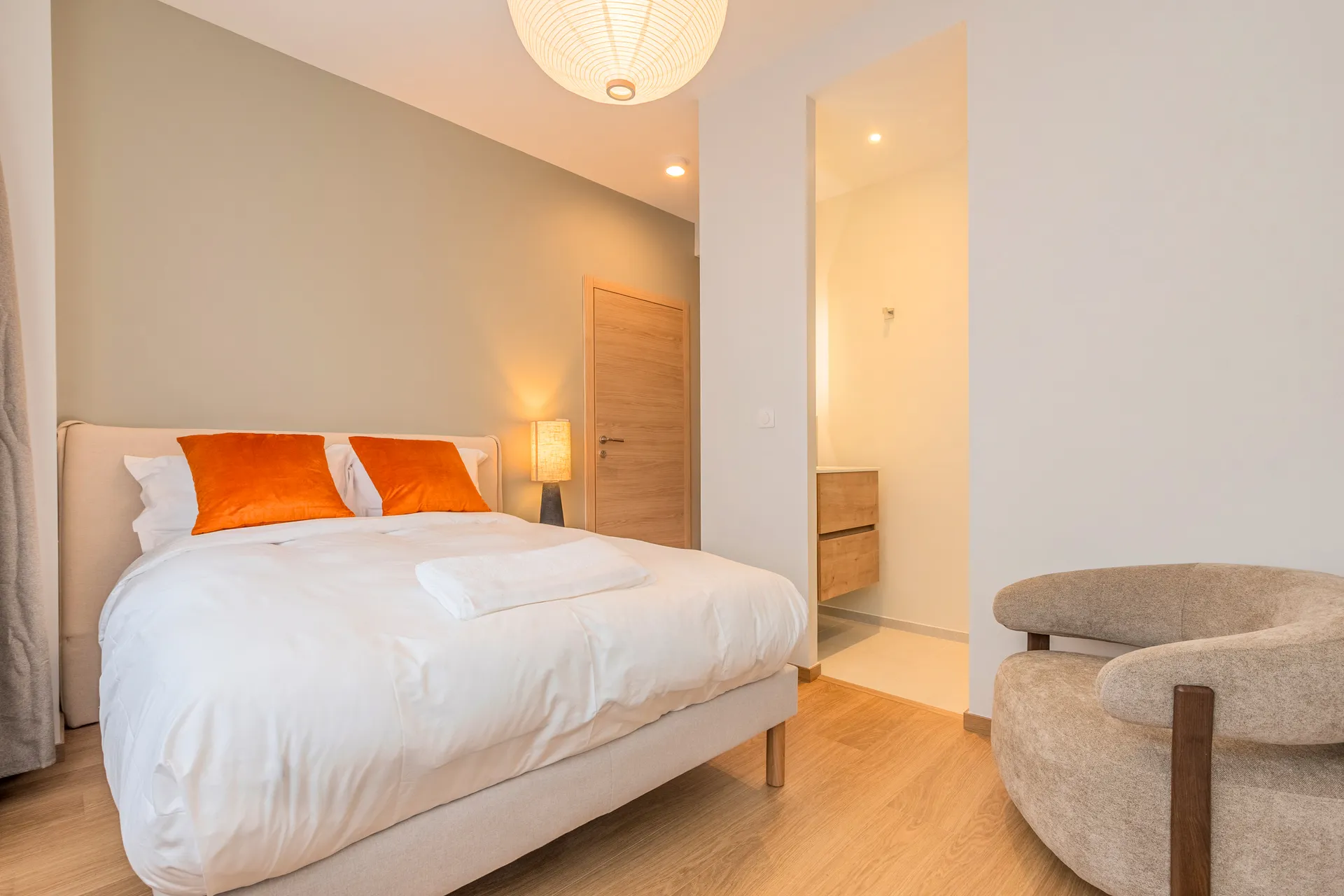 Photo d'une chambre standard — lit, fauteuil et accès à la salle d'eau